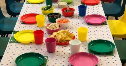 A party table set up for food using colourful reusable plates