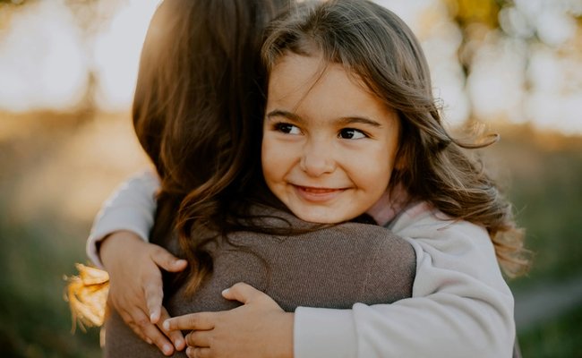 Girl cuddling parent
