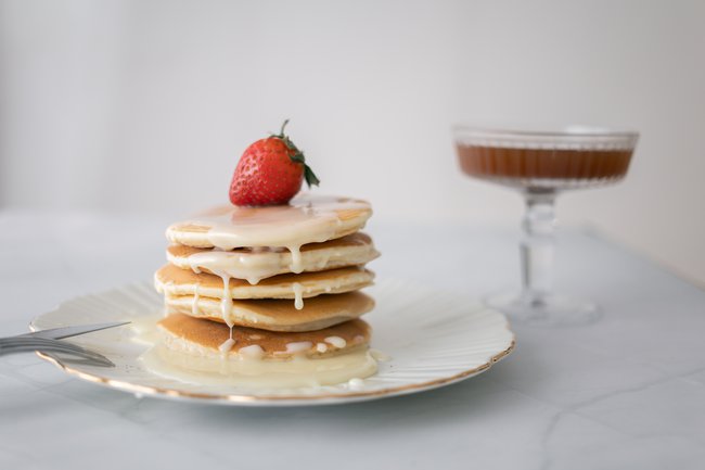 Stack of pancakes with strawberry road and chocolate sauce in a glass