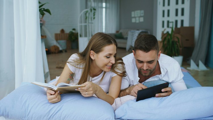Couple on bed reading magazines